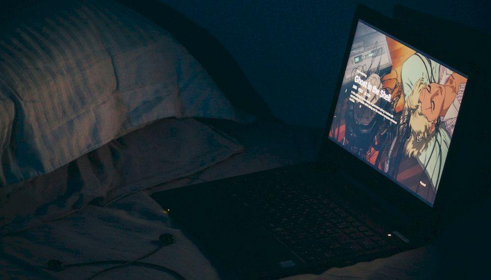 Reproduciendo una película en la cama con el ordenador portátil