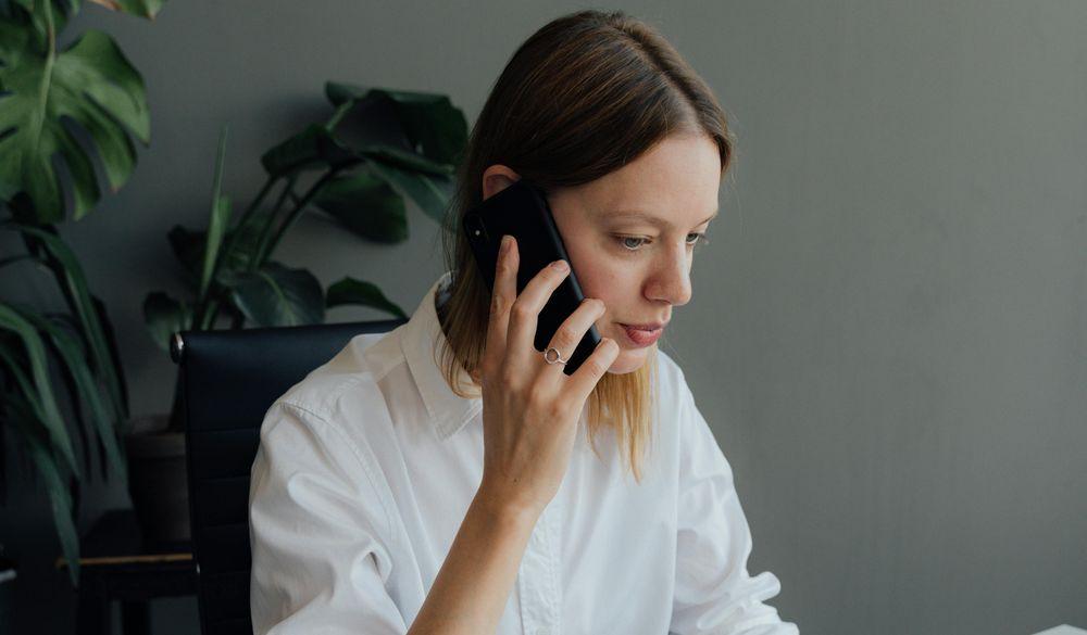 Una mujer llama por teléfono mientras está en el trabajo