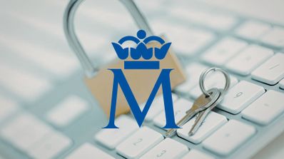 Logotipo azul de la Fábrica Nacional de Moneda y Timbre sobrepuesto sobre un teclado de ordenador con un candado y llaves.