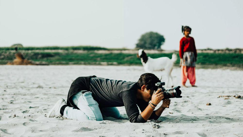 Un fotógrafo hace una foto estando tumbado en la playa
