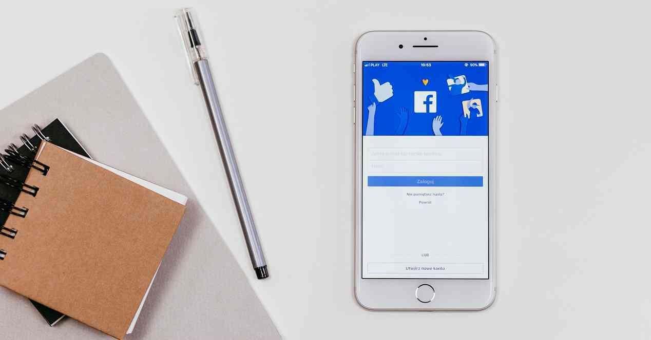 movil sobre una mesa con la app de Facebook abierta