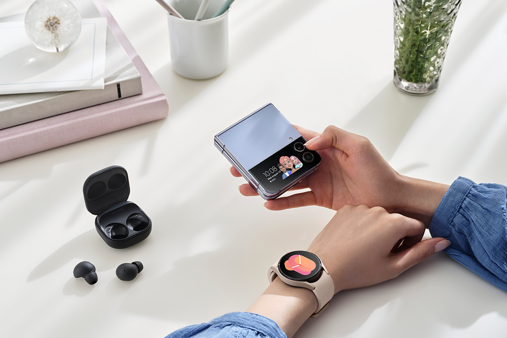 Manos de mujer con Galaxy Z Flip4, Buds Pro2 y reloj galaxy Watch5