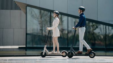 dos personas en un patinete Xiaomi