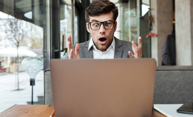Hombre mirando con frustración la pantalla de su smartphone al no encontrar la red WiFi de 5 GHz, con un router WiFi visible al fondo