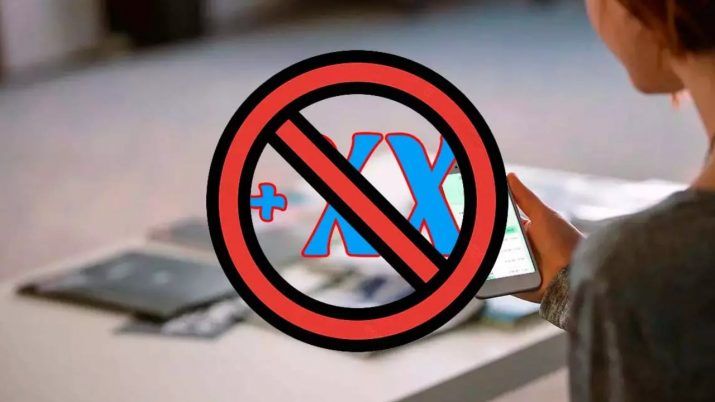 Símbolo de prohibido sobreimpreso en un prefijo telefónico genérico mientras una persona sujeta un móvil.