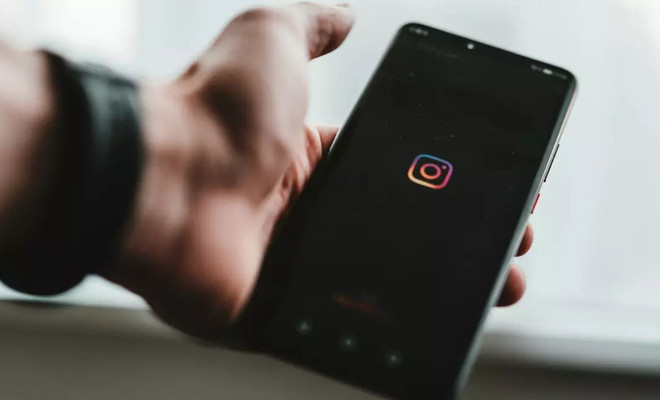 Una majo sujetando un móvil con el logo de Instagram