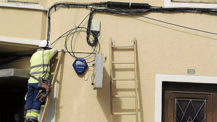 Instalación de cables de fibra óptica en la fachada de un edificio residencial, mostrando el detalle de los conductos verticales y el cableado