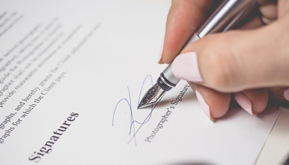 Una mujer utiliza su firma en un documento importante