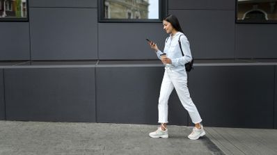 mujer andando con móvil ganando dinero por caminar