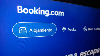 Pantalla de un ordenador portátil mostrando la página de inicio legítima de Booking.com, usada como referencia para la alerta de phishing