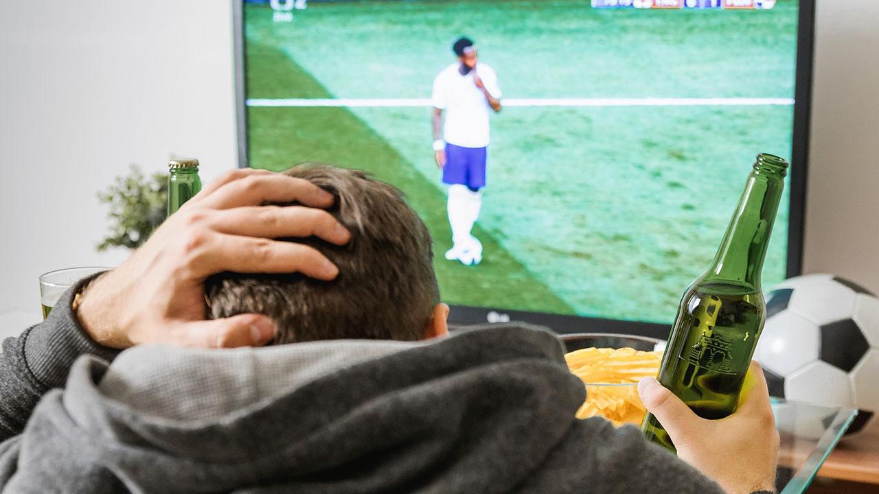 hombre viendo fútbol en la TV