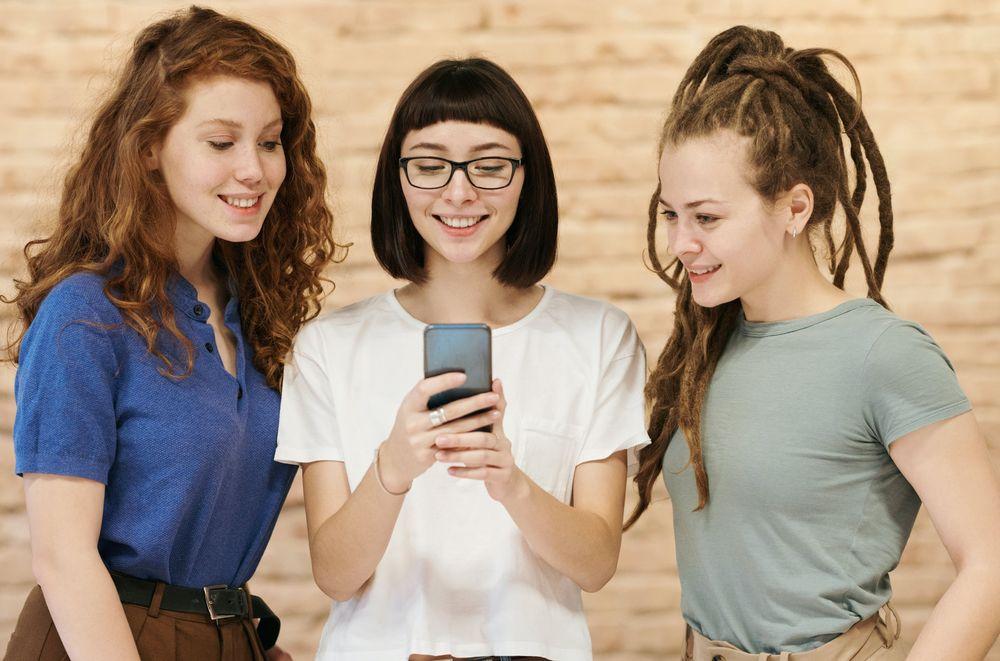 Tres amigas comparten su móvil