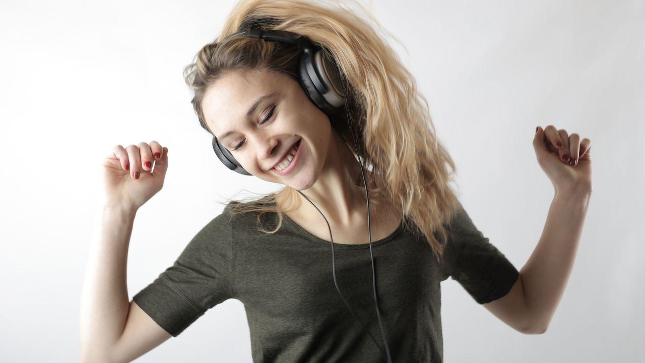 Chica escuchando música y bailando feliz