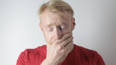 Hombre ojos cerrados y mano en la boca