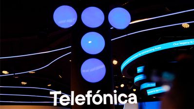 logo de teléfonica en neón sobre varios carteles