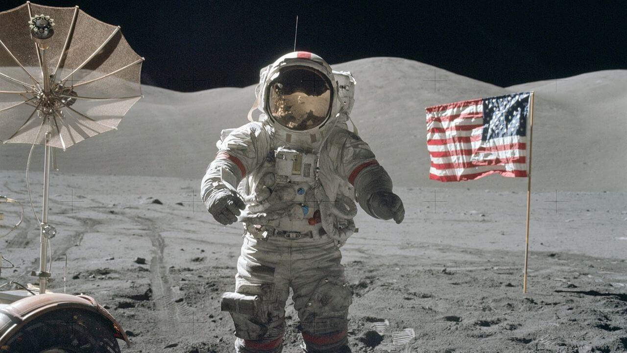 Un astronauta de la NASA pisando la Luna con la bandera de fondo