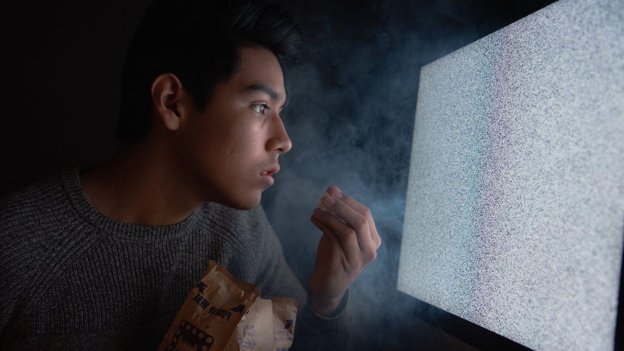Come palomitas mientras mira una tele que ha perdido la señal