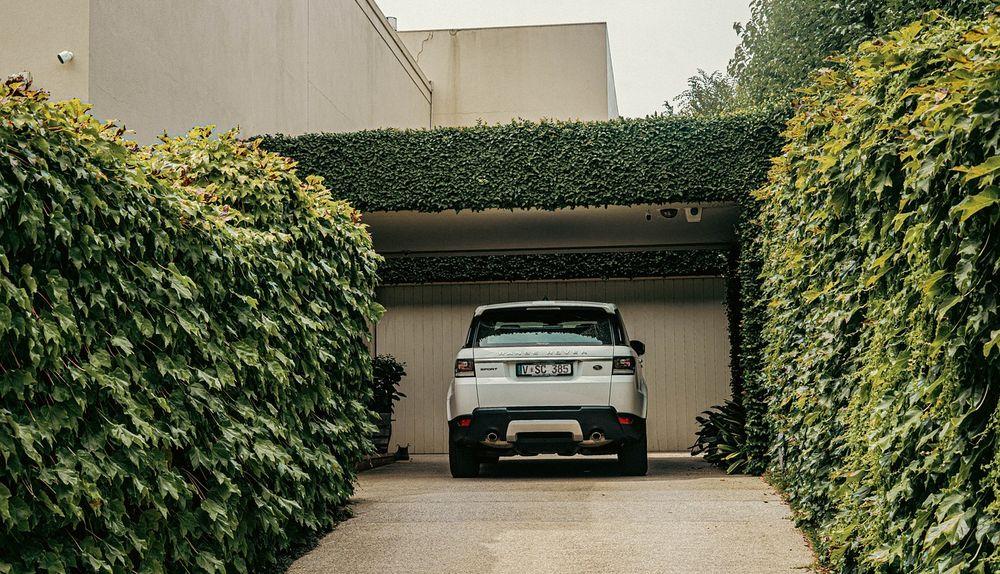 Un coche aparcado en un garaje rodeado de plantas