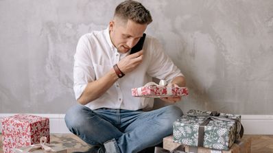 Hablando con el móvil mientras prepara los regalos de Navidad