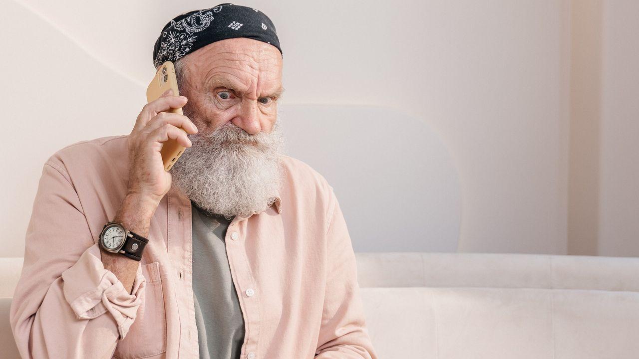 Anciano motero habla enfadado con el móvil