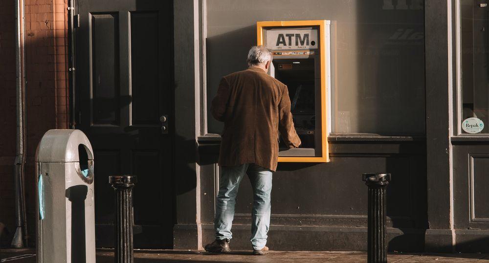Un anciano saca dinero de un cajero automático