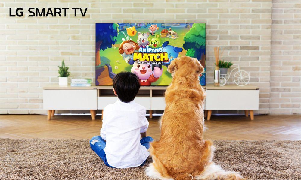 Niño y mascota mirando un juego en una TV Smart de LG
