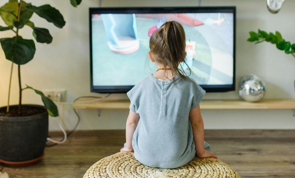 Una niña sentada viendo la televisión