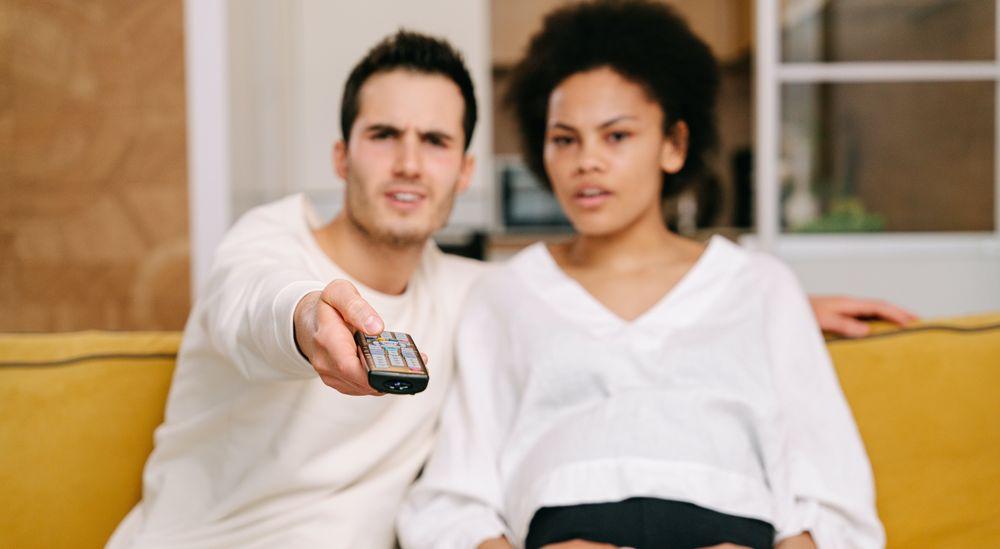 Una pareja usa el mando a distancia para cambiar de canal