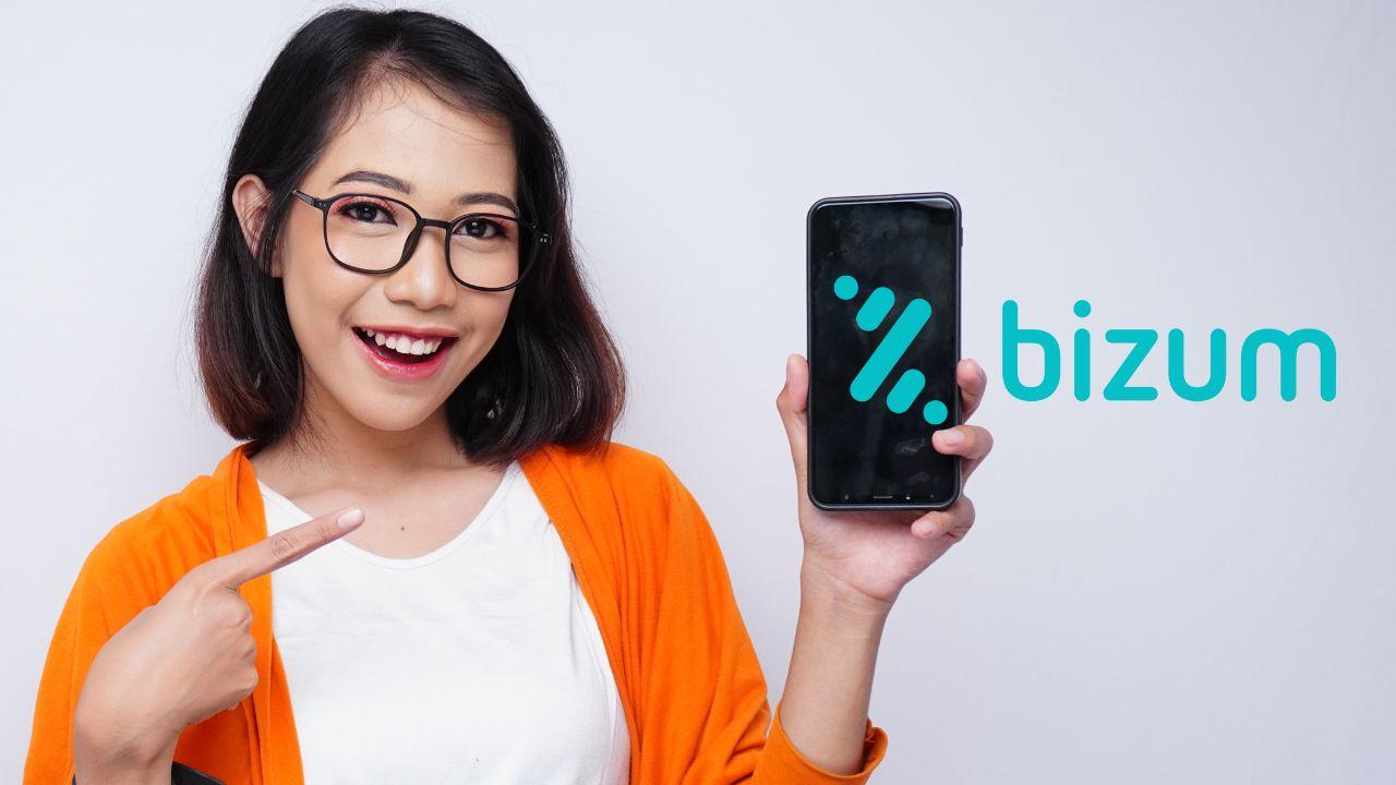 Chica feliz mostrando el logo de Bizum en el móvil