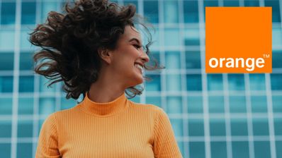 Una chica feliz moviendo el pelo con el logo de Orange en la imagen
