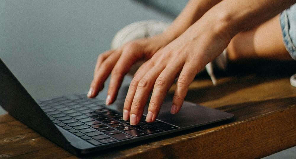 Tecleando en un ordenador portátil con las dos manos