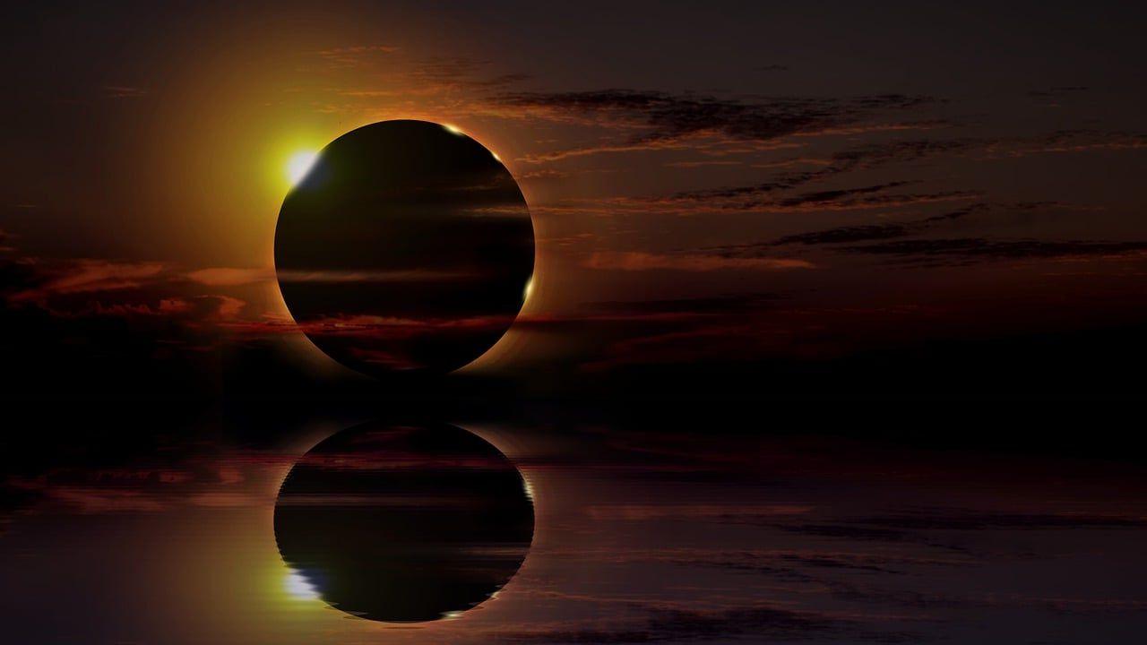 Un eclipse solar visto con un reflejo sobre el agua