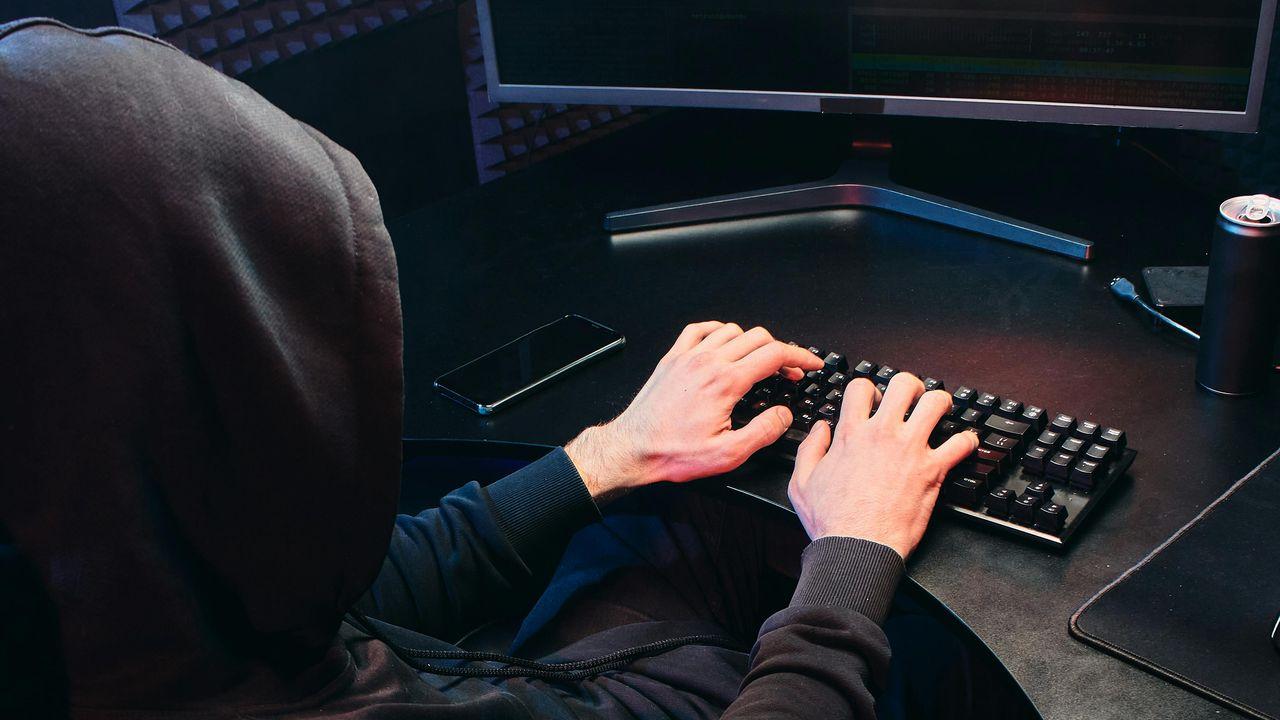 Hacker usa un teclado con las dos manos para atacar con rapidez