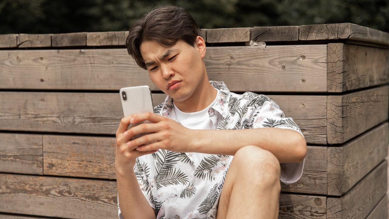 Hombre está molesto mientras mira su teléfono móvil