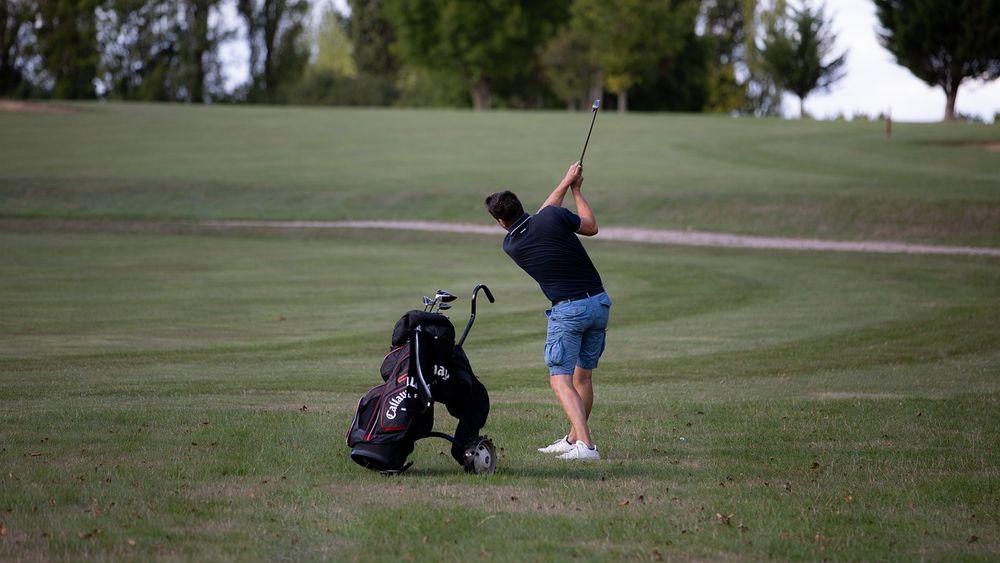 Un jugador dando un golpe en el campo de golf