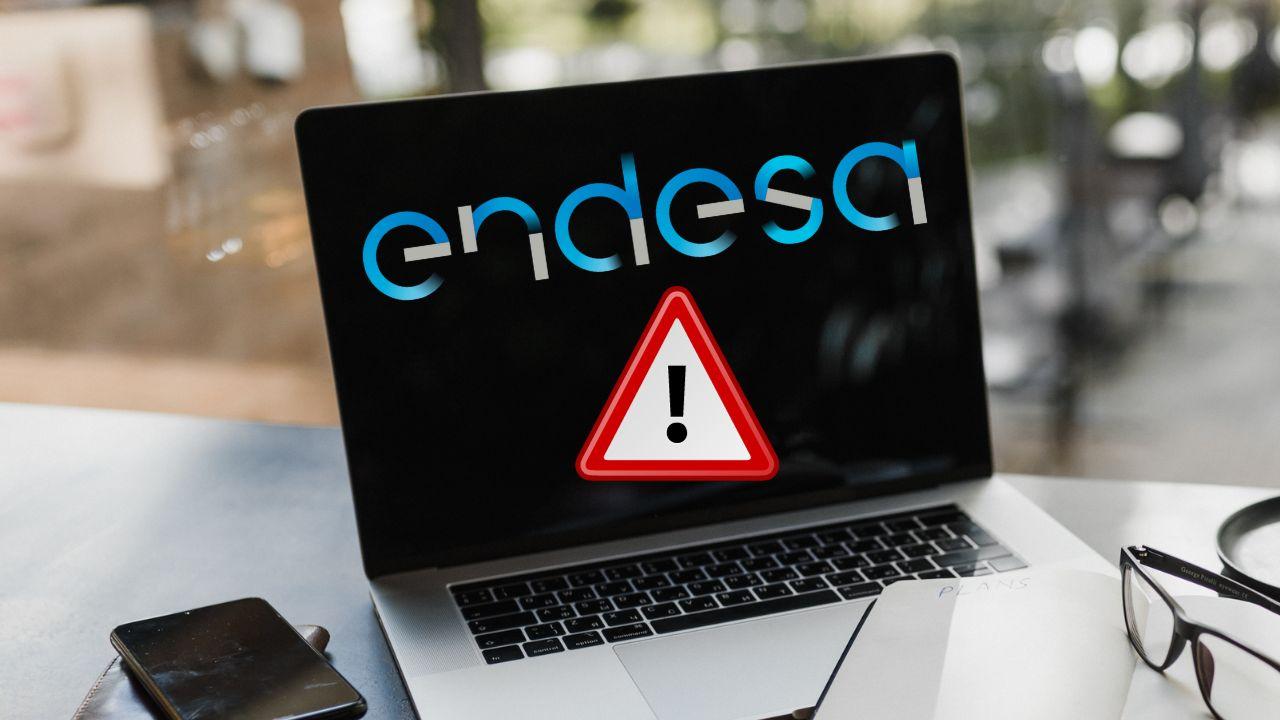 Un ordenador portátil con el logo de Endesa y una señal de alarma