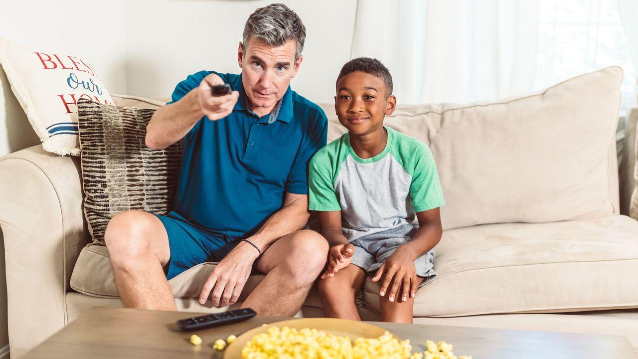 Un padre y su hijo viendo juntos deportes en la TV