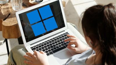 Una chica utiliza un ordenador portátil con el logo de Windows 11 en pantalla
