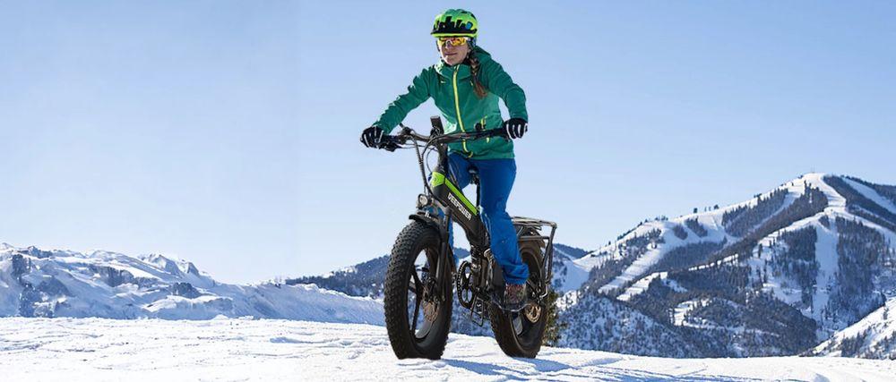 Chica utilizando la bicicleta eléctrica DeePower sobre terreno de nieve