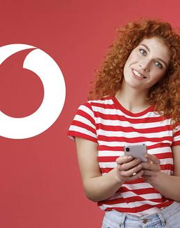 mujer con el móvil con logo Vodafone