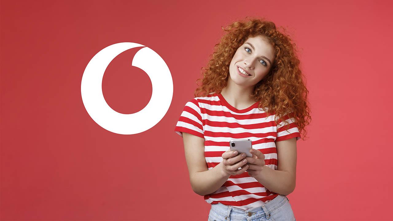 mujer con el móvil con logo Vodafone