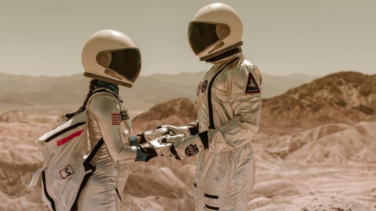 Una pareja de astronautas explora un planeta desconocido