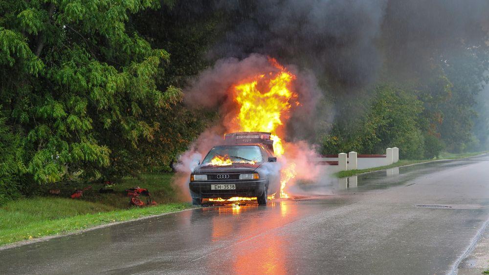 Un coche con fuego después de un accidente en carretera