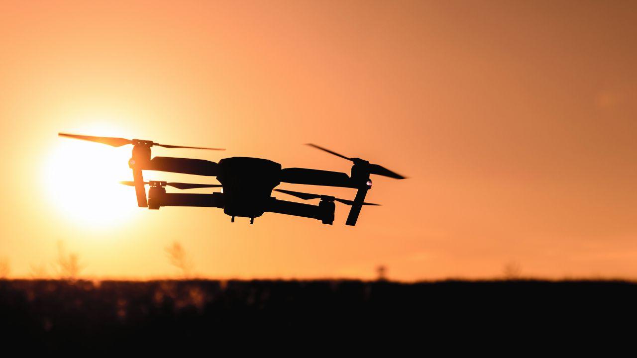 Un dron volando con el sol de fondo