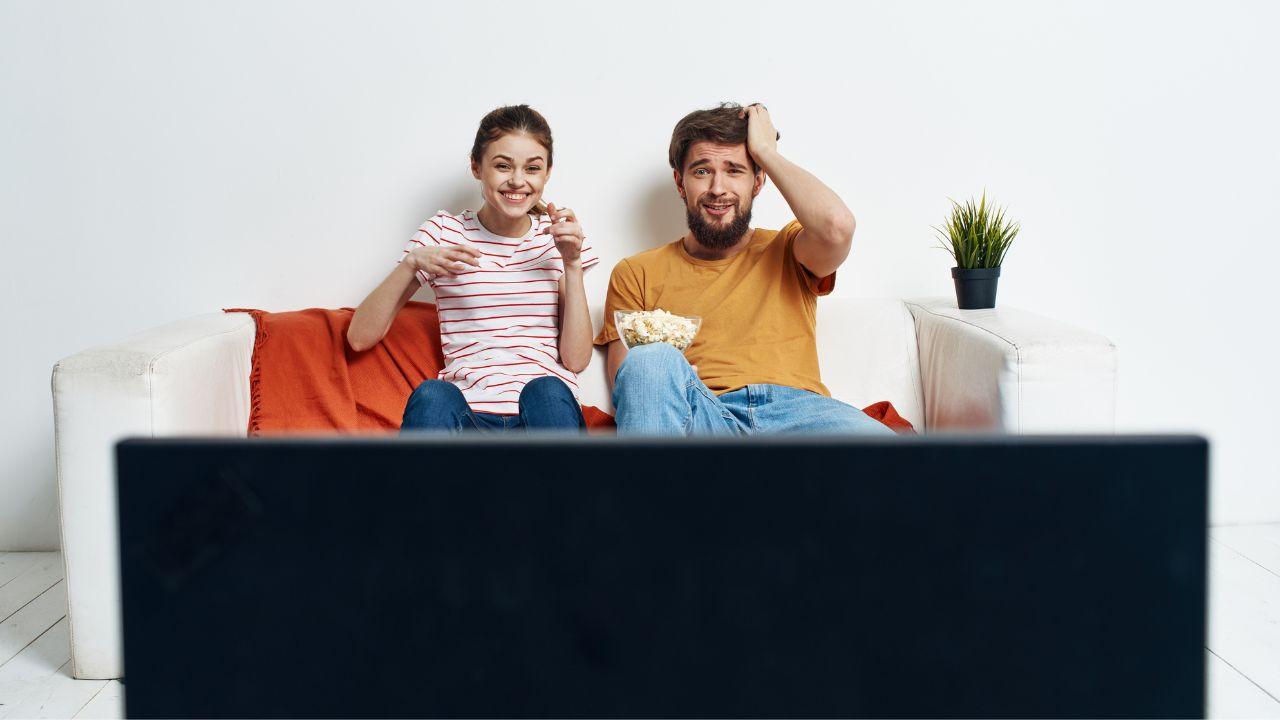 Una pareja se sorprende mientras está viendo la televisión