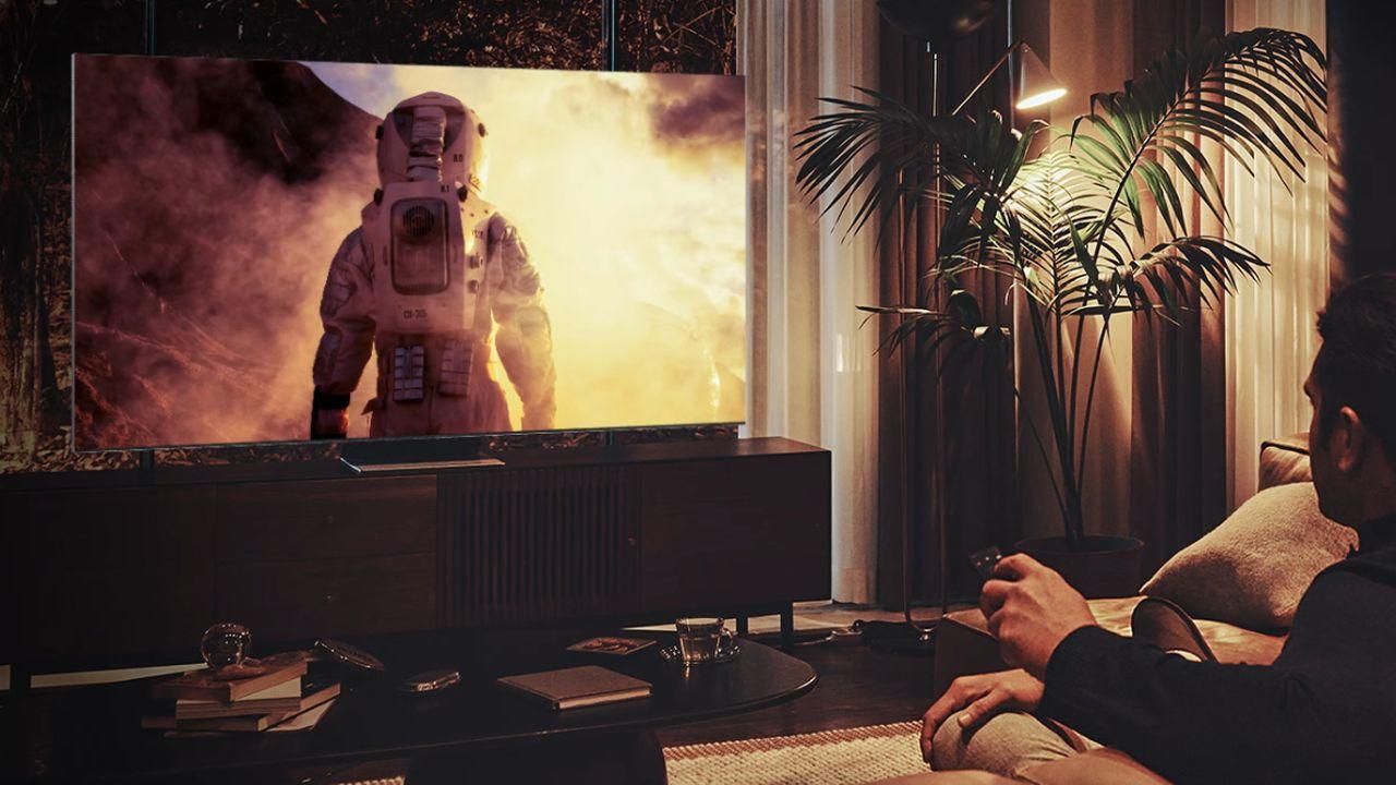 Un hombre está sentado viendo una película en su Smart TV de Samsung
