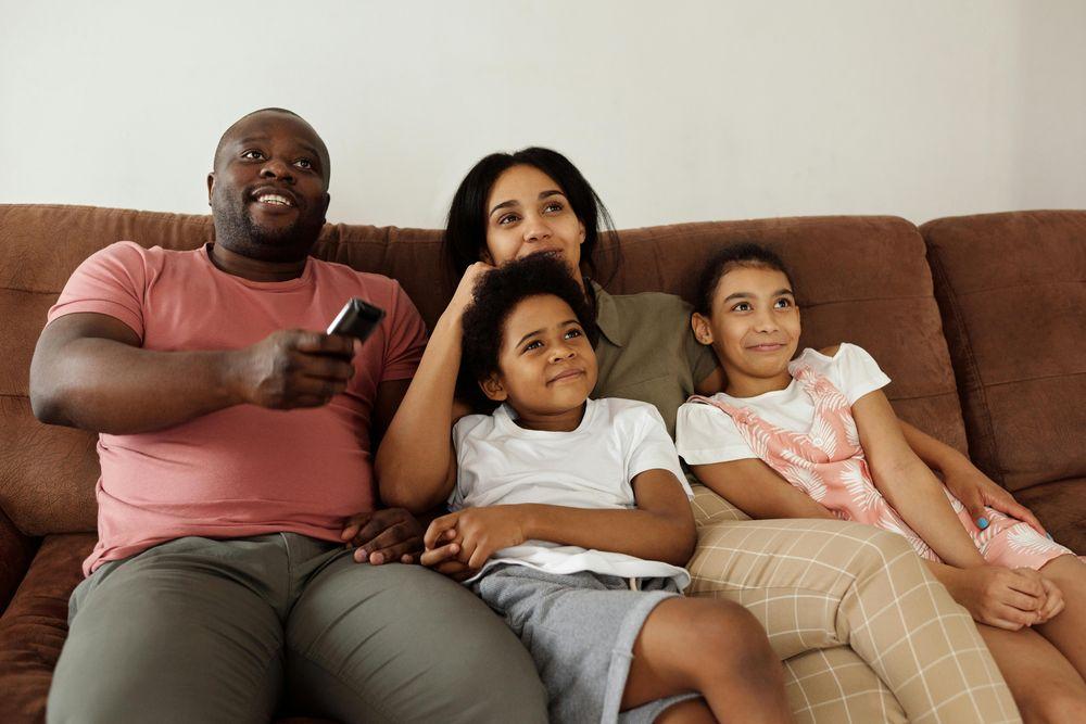 Una familia feliz reunida viendo la televisión