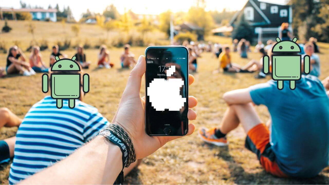 Un chico con el iPhone rodeado de amigos que tienen Android