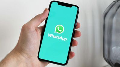 Un usuario sujeta su móvil con la aplicación de WhatsApp mientras carga