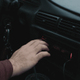 persona interactuando con la radio en un coche